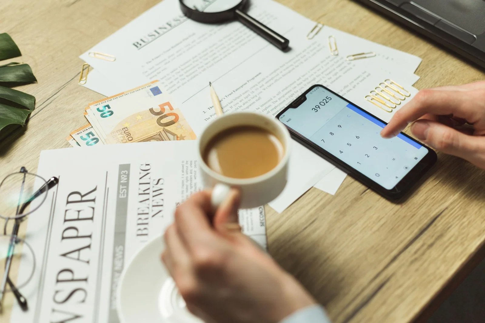 Deux dossiers d'aides sociales posés sur un bureau avec une calculatrice et une tasse de café